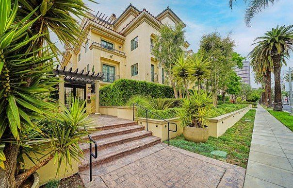 A large building with stairs leading up to it and palm trees in front of it.