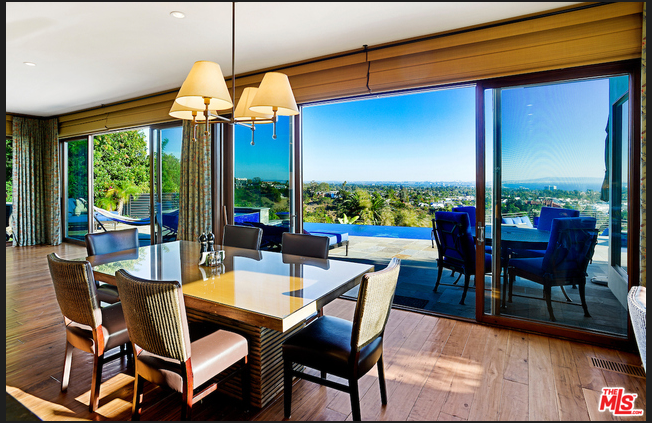 A dining room with a table and chairs and a view of the ocean