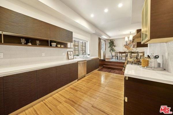 A kitchen with wooden floors and white counter tops