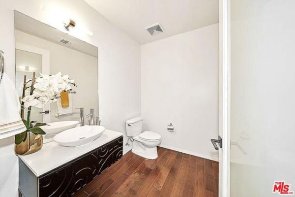 A bathroom with a sink , toilet and mirror.