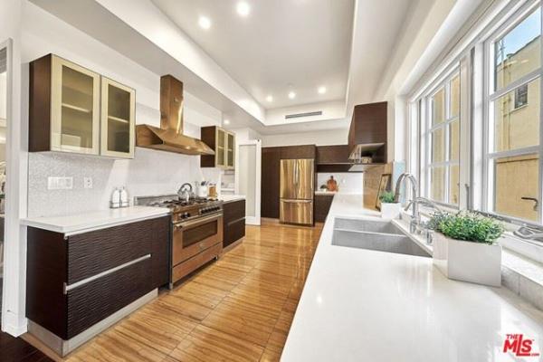 A kitchen with stainless steel appliances and white counter tops