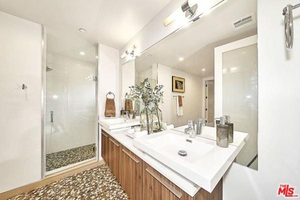 A bathroom with two sinks and a walk in shower.