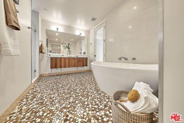 A bathroom with a bathtub and a basket of towels.