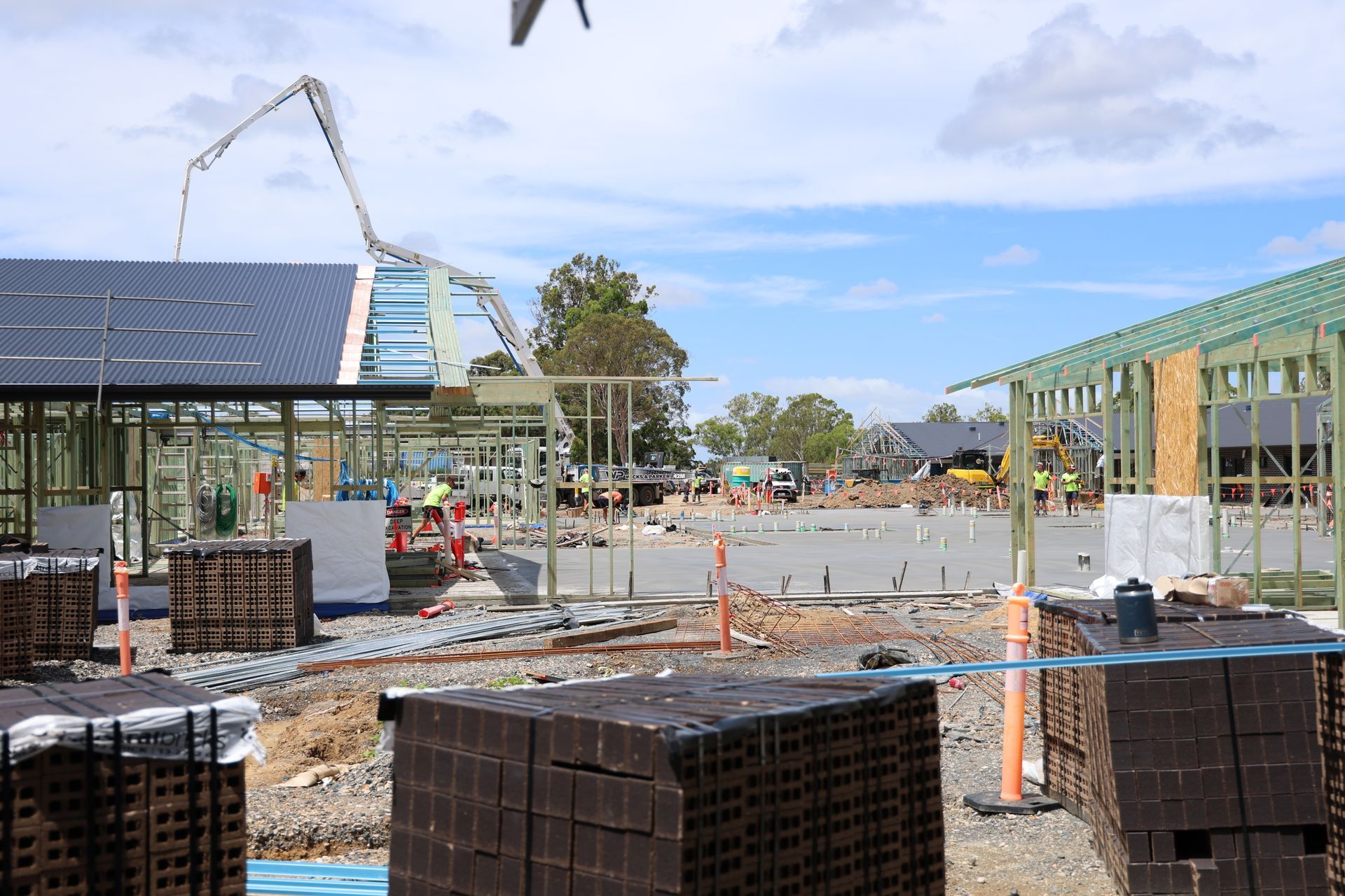 Construction site with concrete pump pouring concrete, partially built buildings, stacks of bricks— Chill-Rite Refrigeration and Air Conditioning in Coffs Harbour, NSW