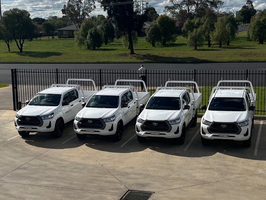 A Row of White Pickup Trucks Are Parked in a Parking Lot — Chill-Rite Refrigeration and Air Conditioning in Dubbo, NSW
