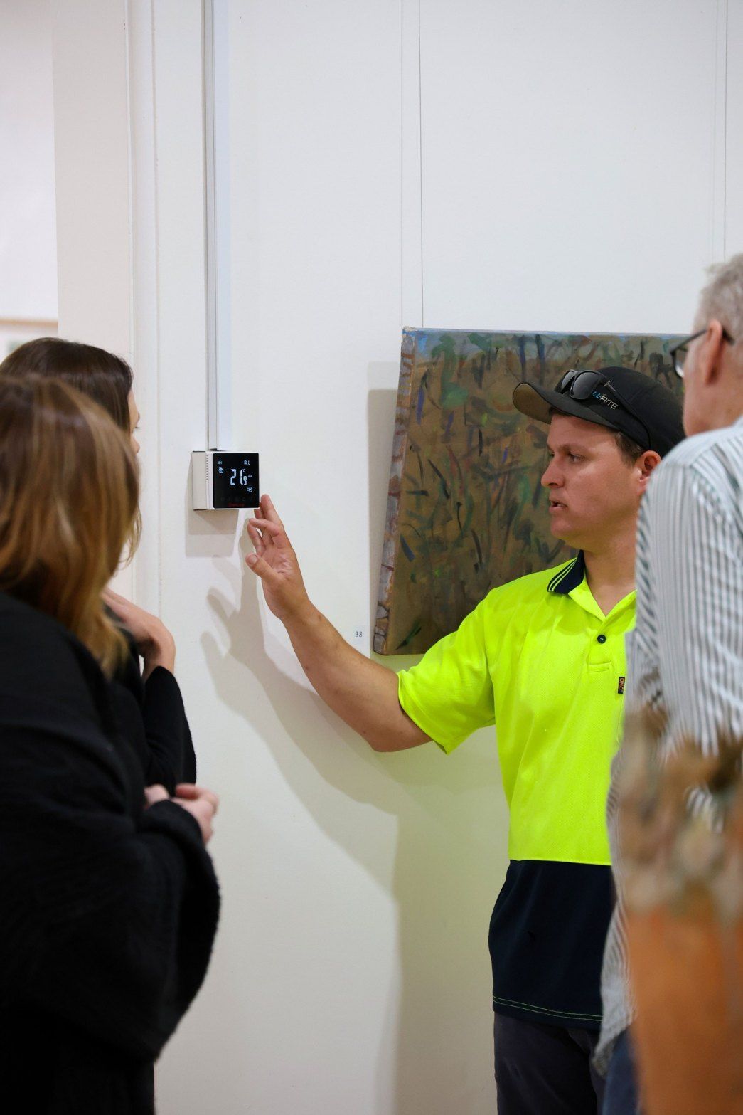 A Man in a Neon Yellow Shirt is Talking to a Group of People in a Room — Chill-Rite Refrigeration and Air Conditioning in Coffs Harbour, NSW