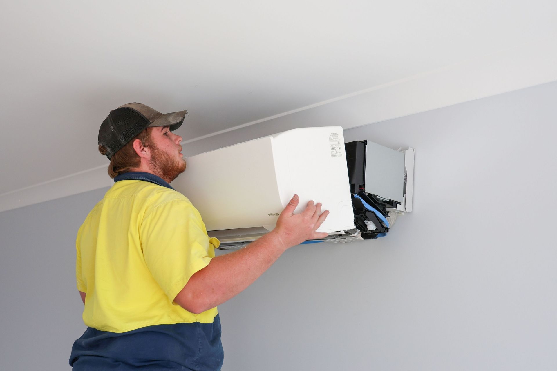 A Person Inspecting The Air Conditioning Unit