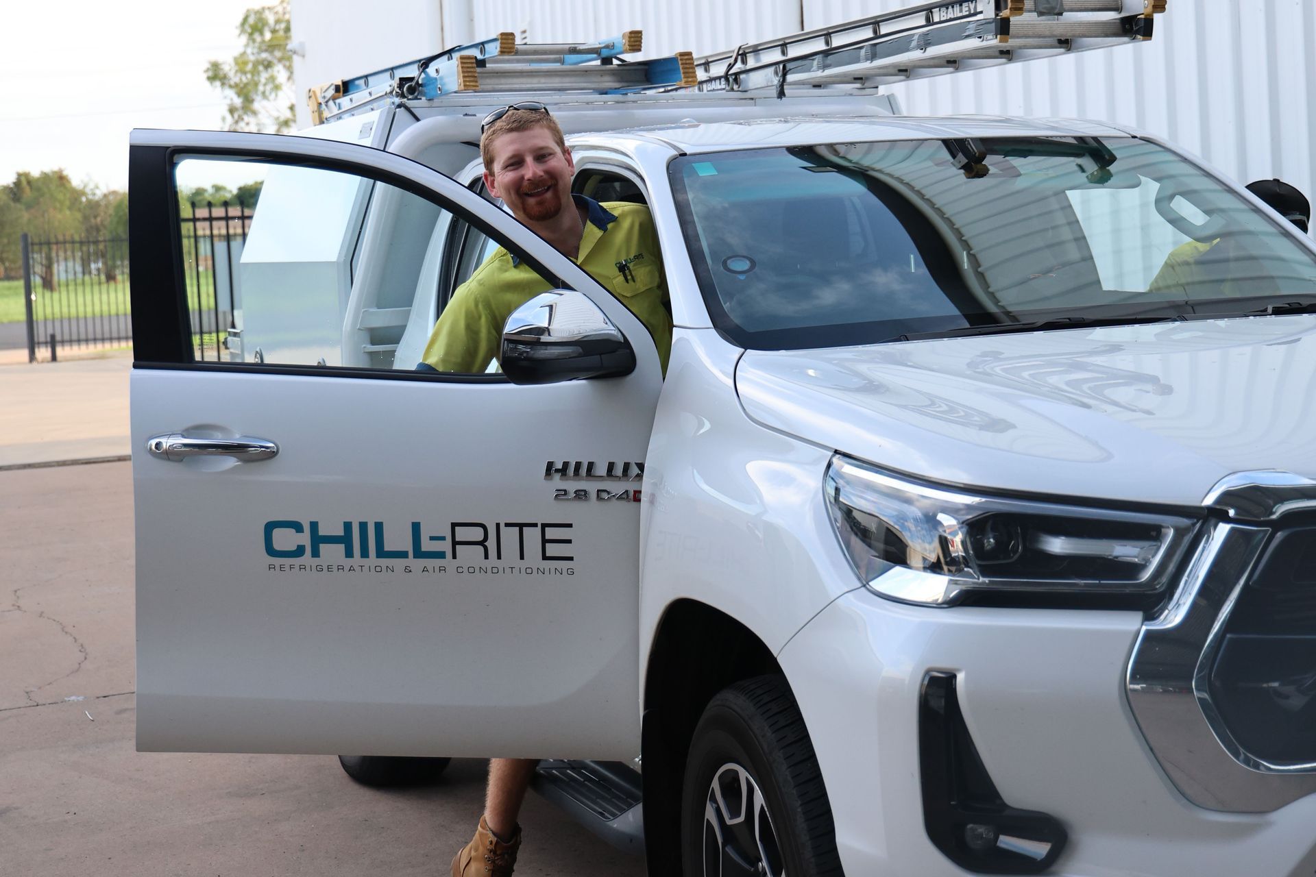A Group of Men Are Digging in the Dirt in Front of a Building — Chill-Rite Refrigeration and Air Conditioning in Dubbo, NSW