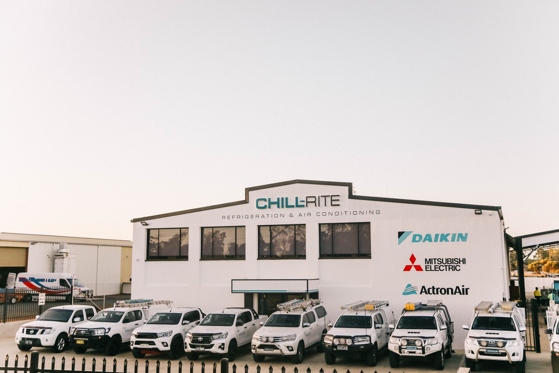 A Large White Building With a Lot of Windows and Logos on It — Chill-Rite Refrigeration and Air Conditioning in Dubbo, NSW