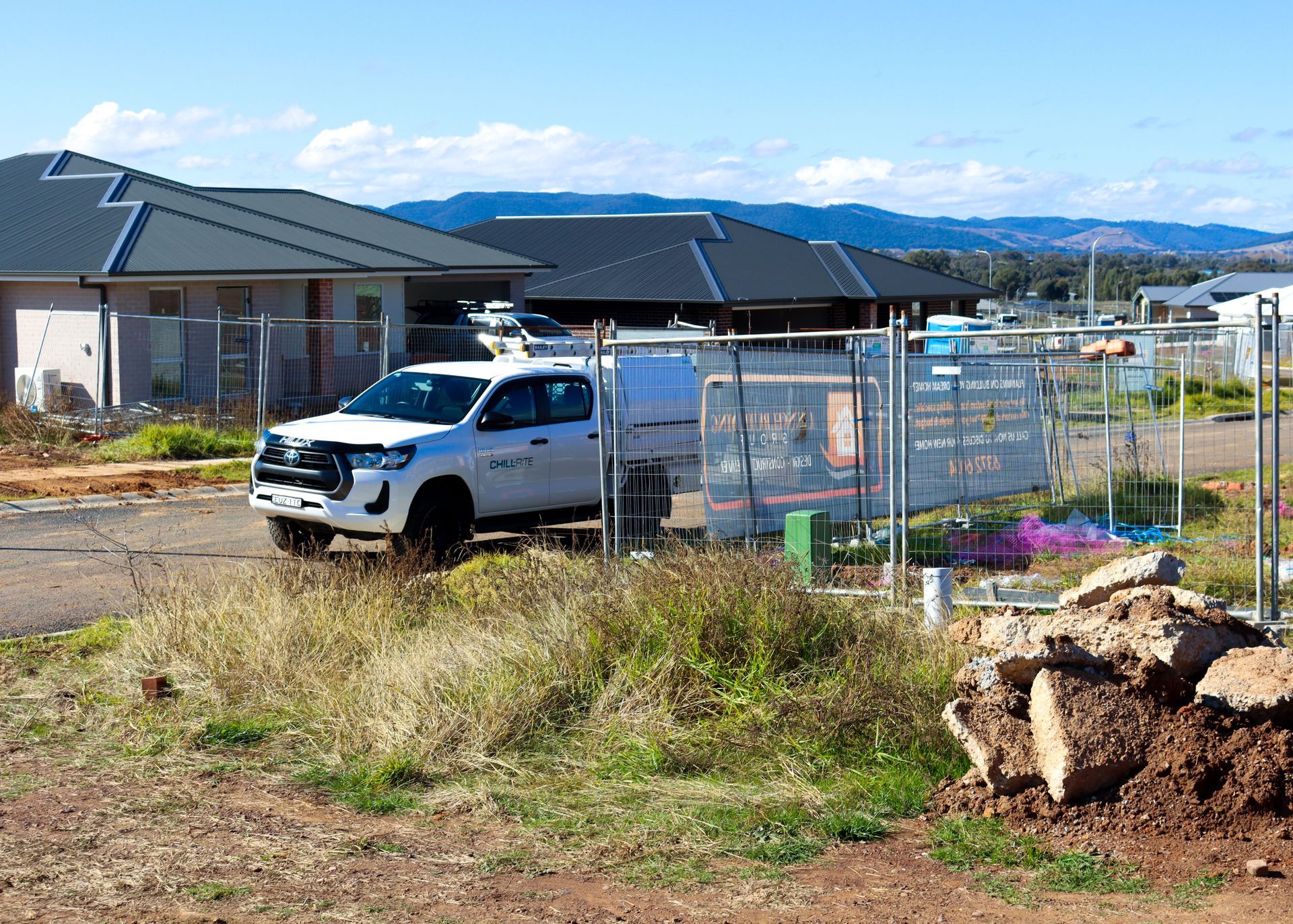 White pickup truck parked near construction fencing with houses in the background on a sunny day— Chill-Rite Refrigeration and Air Conditioning in Mudgee, NSW