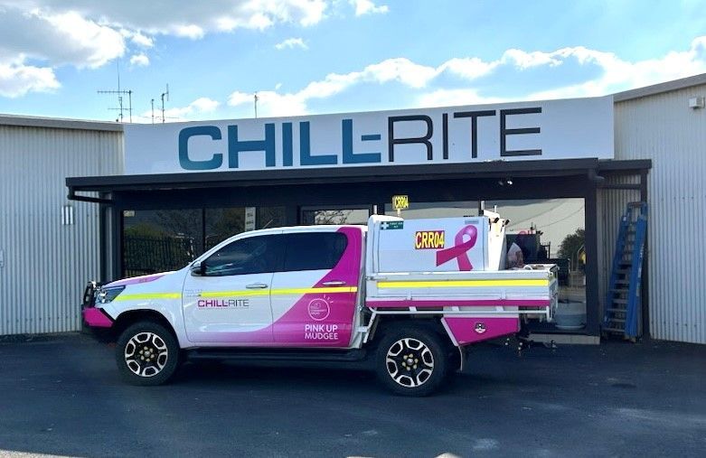 Pink and white Chill-Rite service truck parked in front of a building with the company's sign— Chill-Rite Refrigeration and Air Conditioning in Dubbo, NSW