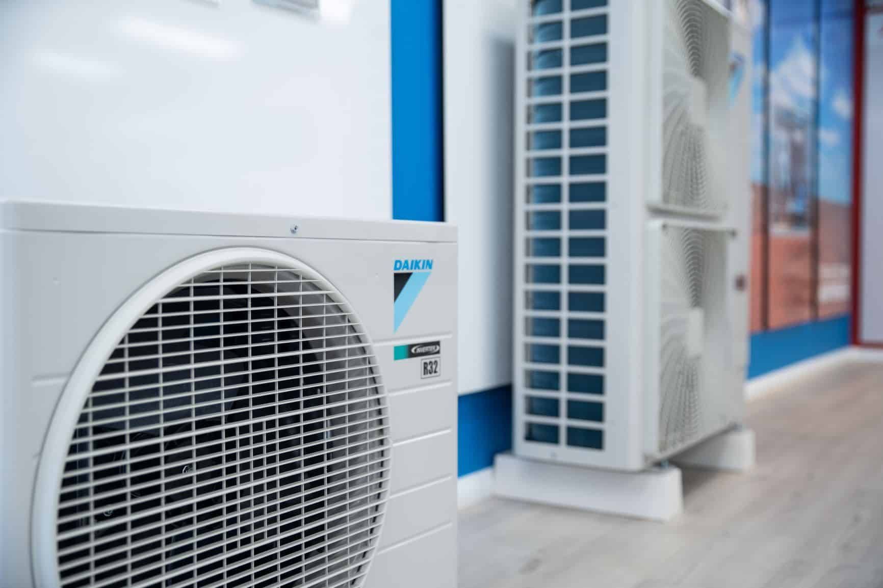 A White Air Conditioner is Sitting Next to a Blue Wall in a Room — Chill-Rite Refrigeration and Air Conditioning in Coffs Harbour, NSW
