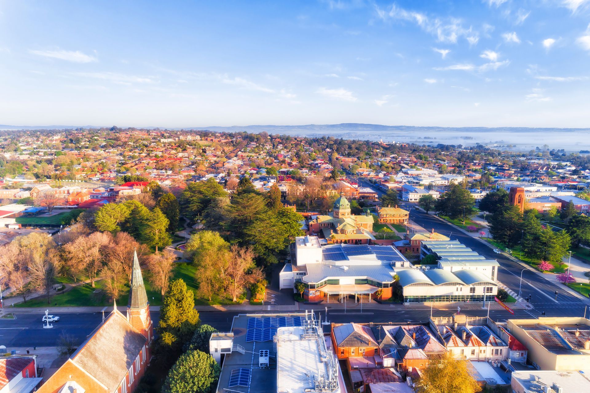 Aerial view of a town with buildings, trees, and road under a blue sky— Chill-Rite Refrigeration and Air Conditioning in Dubbo, NSW