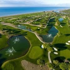 An aerial view of a golf course with a fountain in the middle of it.