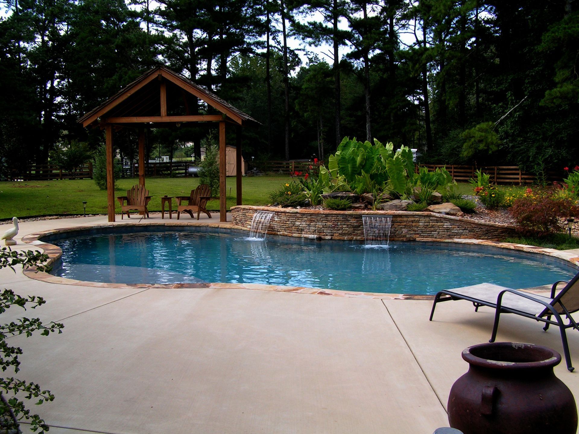 A large swimming pool with a gazebo in the background