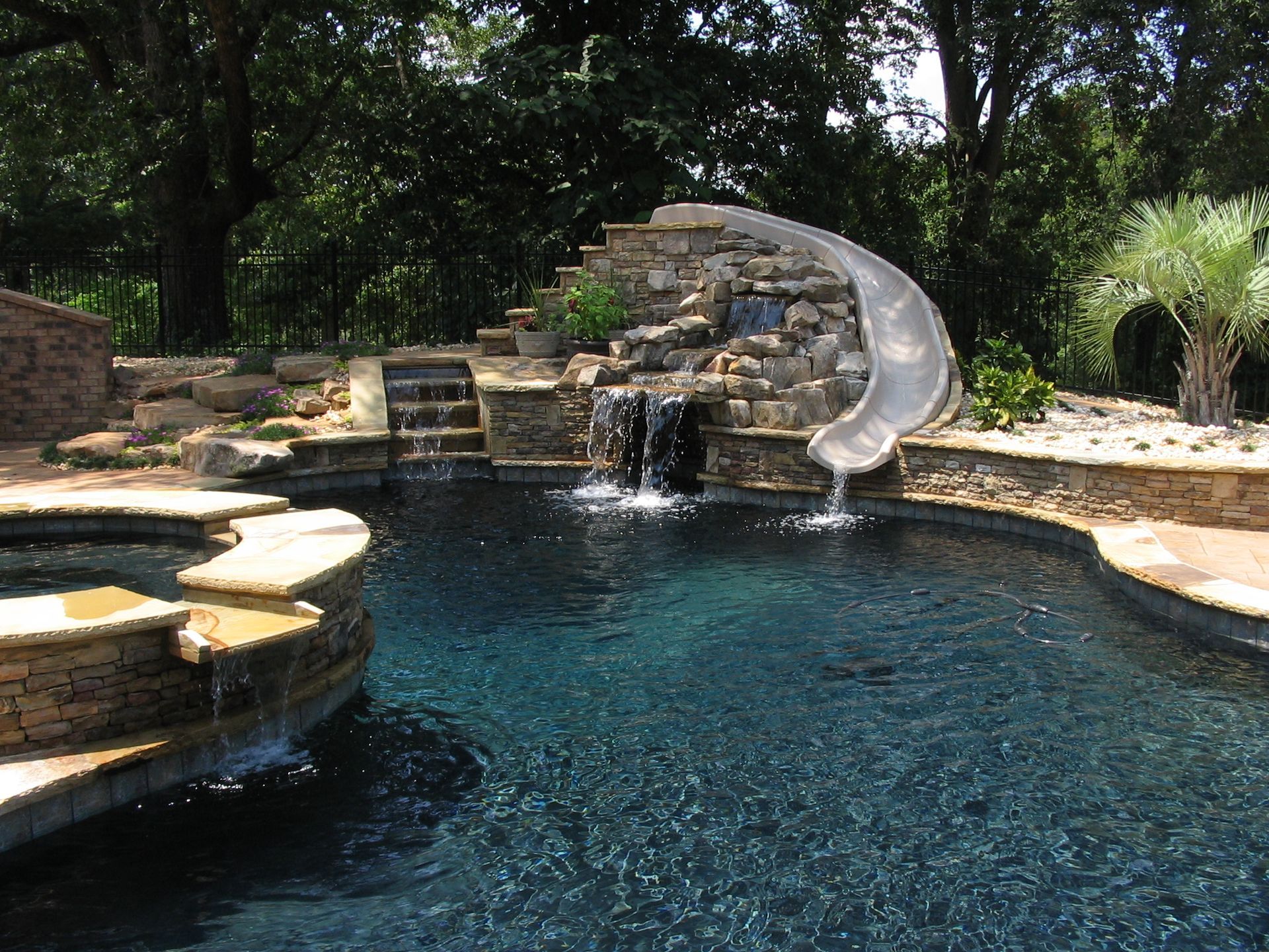 A swimming pool with a water slide and a waterfall