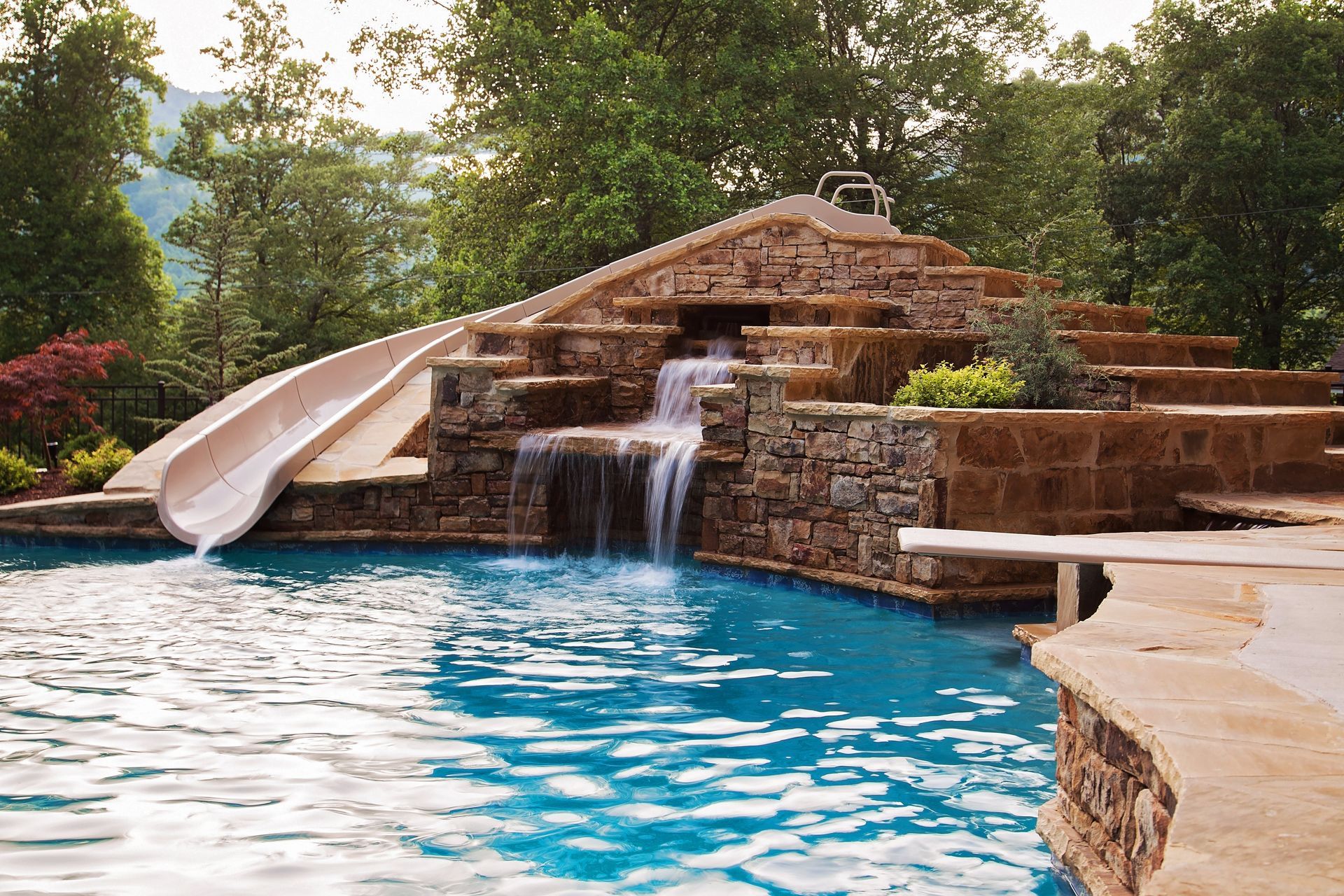 A swimming pool with a water slide and a waterfall