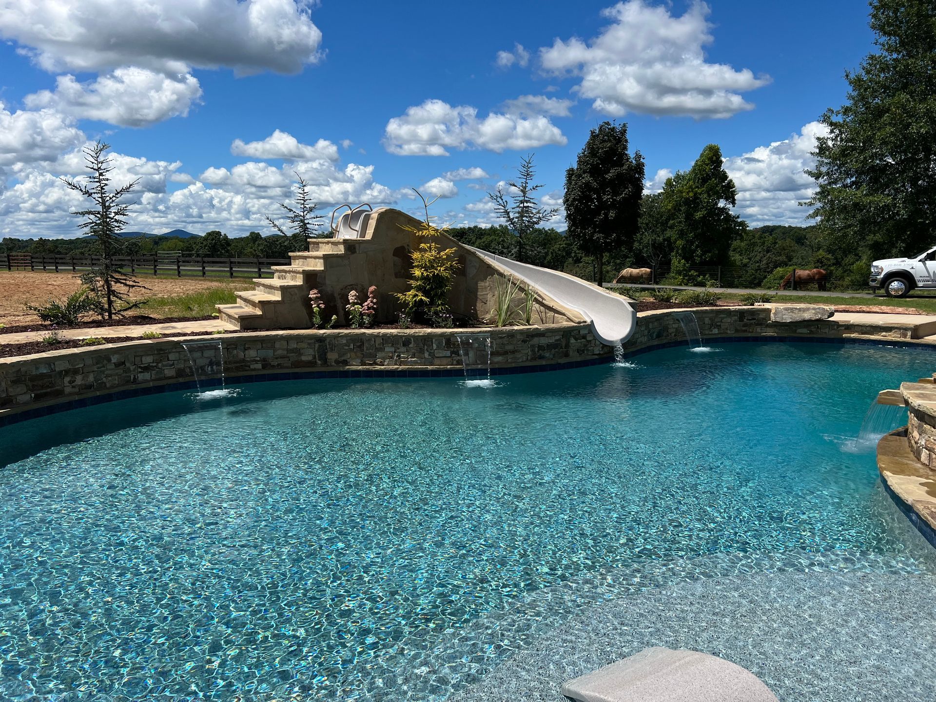 A large swimming pool with a water slide and stairs