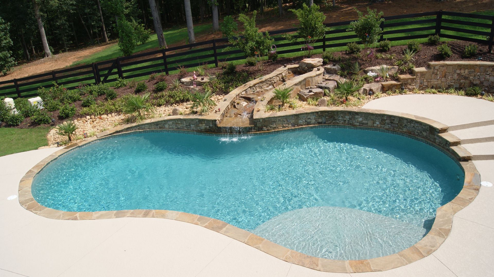 A large swimming pool with a fence in the background