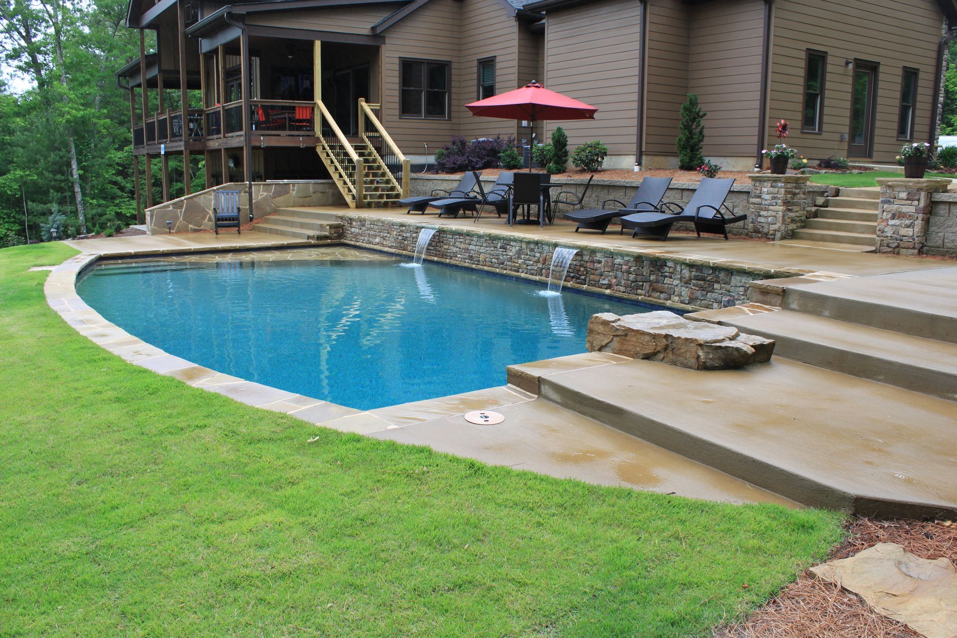 A large swimming pool is in the backyard of a house