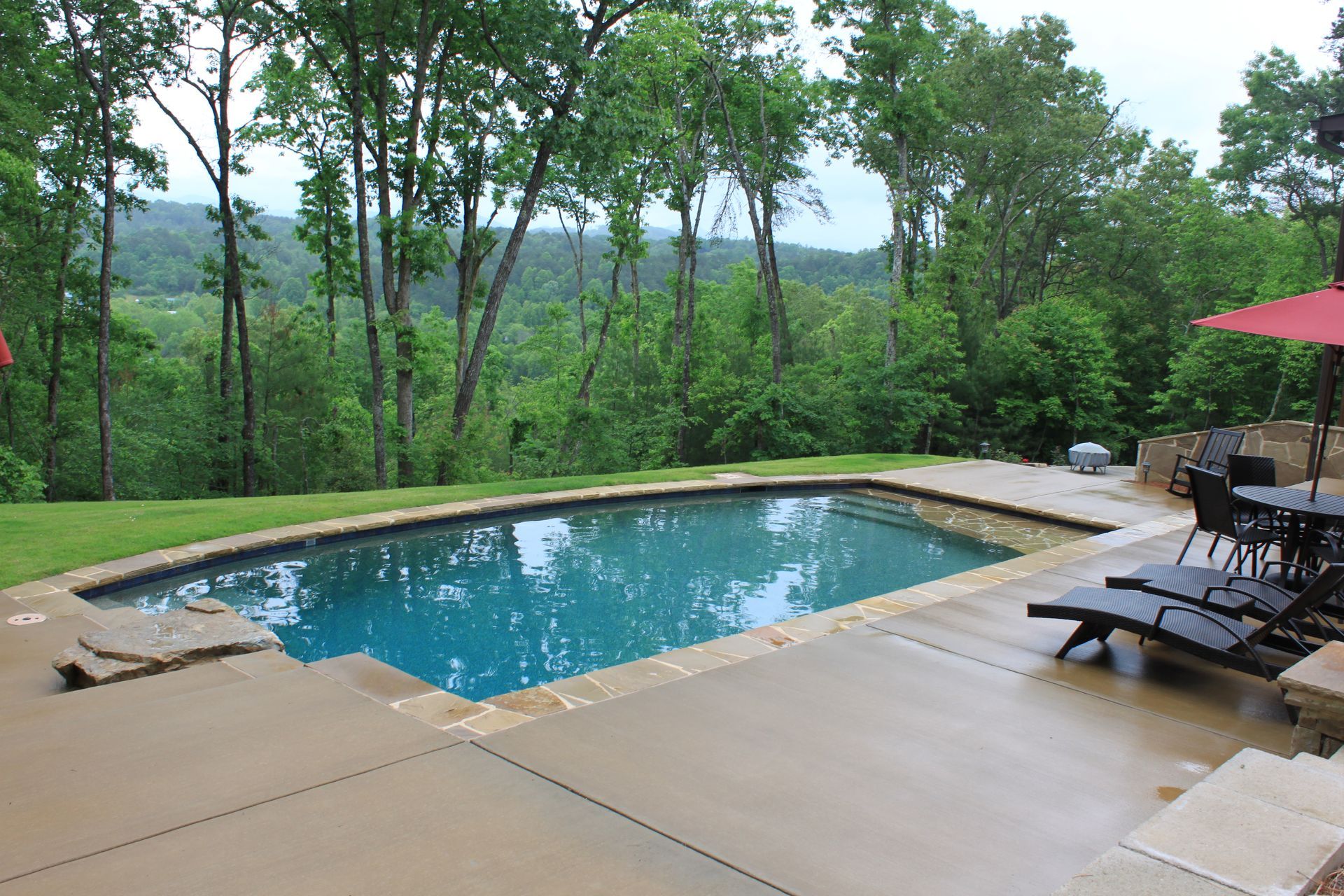 A large swimming pool surrounded by chairs and umbrellas