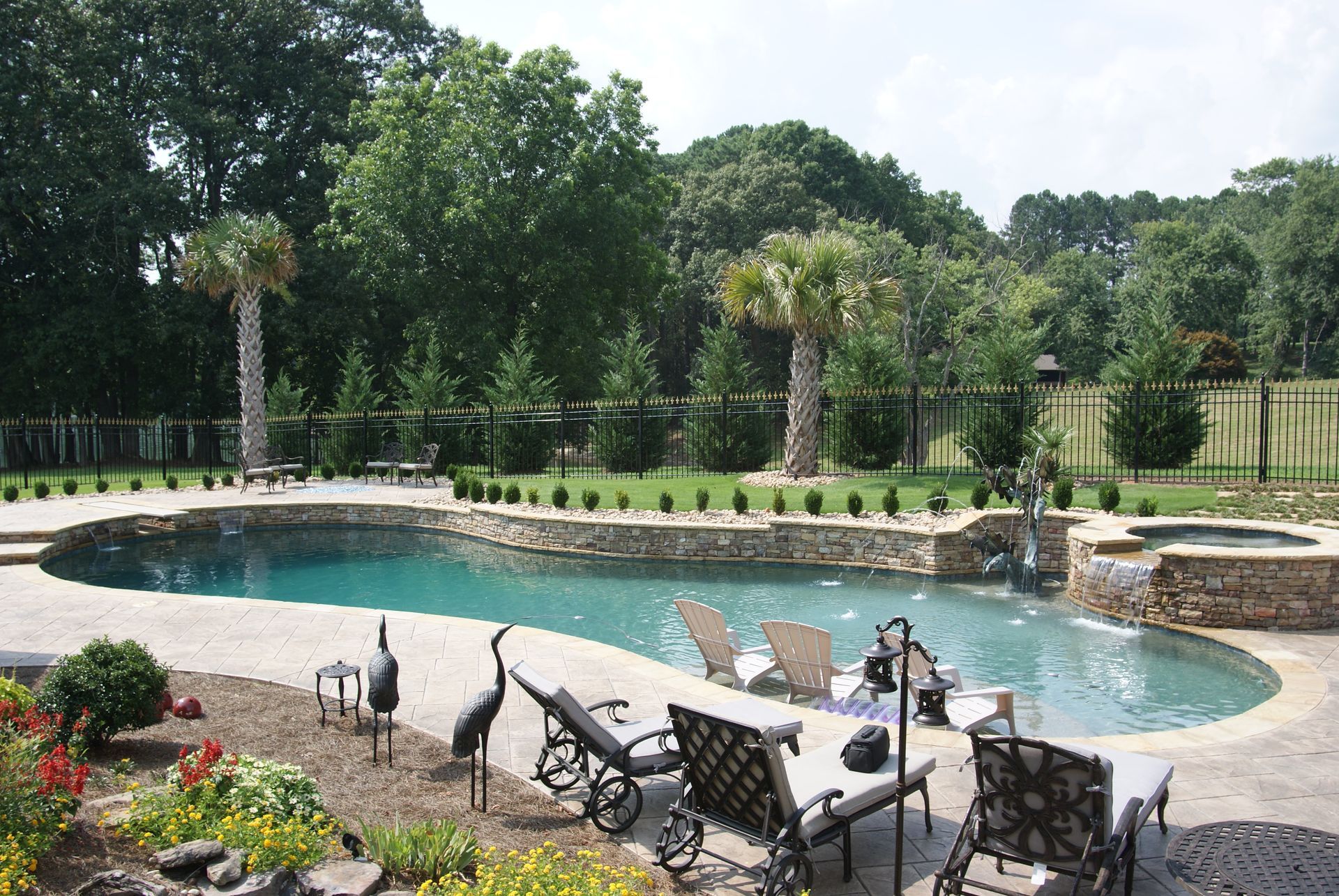 A large swimming pool surrounded by lawn chairs and palm trees