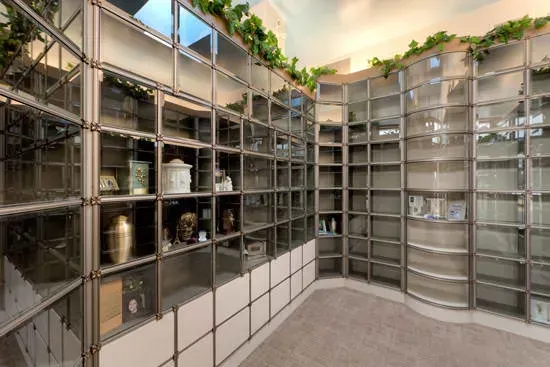 Modern columbarium with rows of gray niches and urns in a bright indoor memorial room