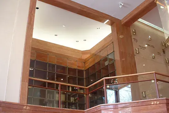 Modern lobby with wood beams, glass railing, and high ceiling