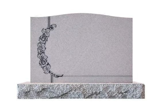 Gravestone with a floral vine engraving on the left side, resting on a stone base.