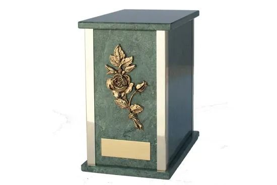Decorative green and gold urn with floral relief on a dark base