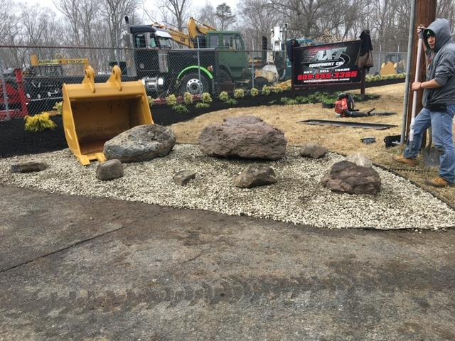 A man is standing in front of a pile of rocks.
