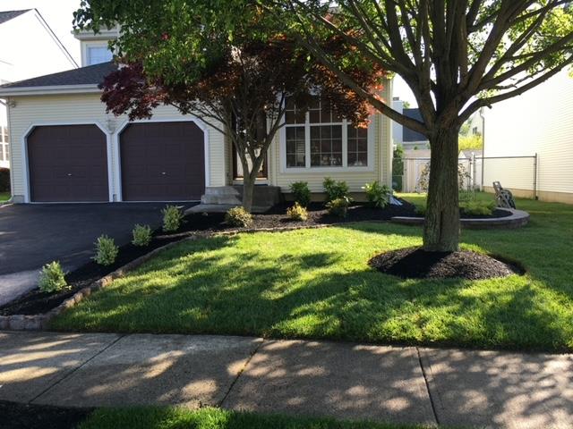 A house with two garages and a tree in front of it