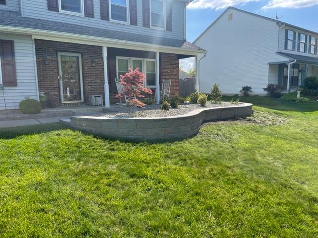 A brick house with a lush green lawn in front of it.