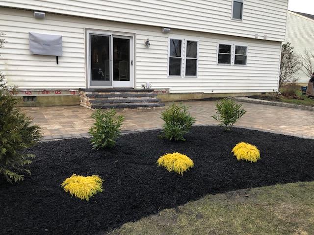 A white house with a patio and flowers in front of it