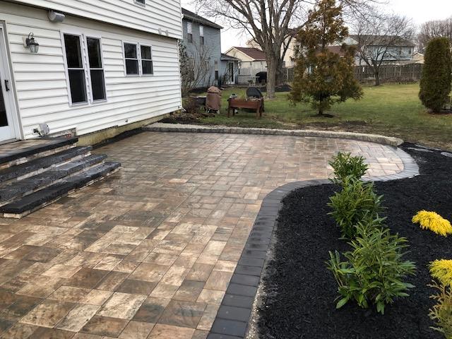 There is a patio in the backyard of a house.