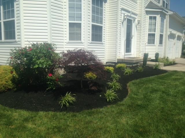 A white house with a lush green lawn in front of it.