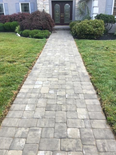 A brick walkway leading to the front door of a house