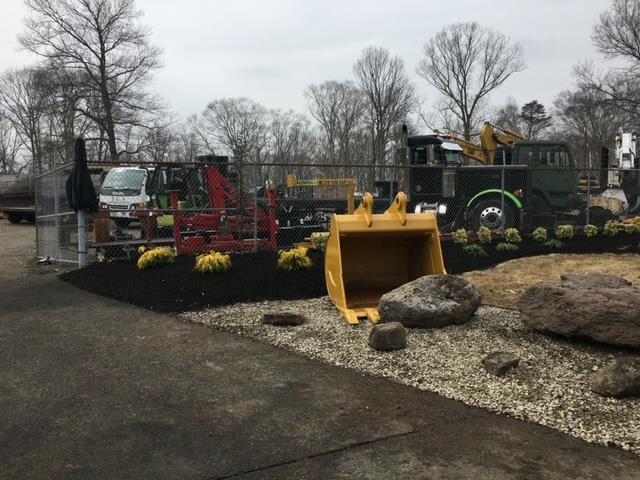 A large yellow bucket sits in front of a truck
