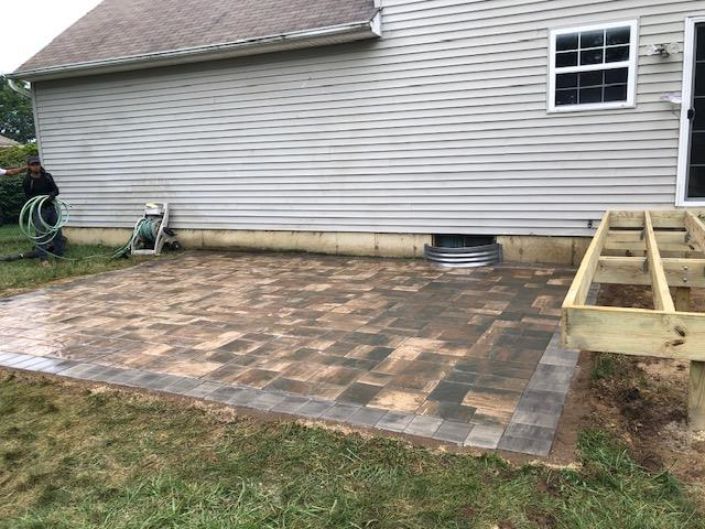 A patio is being built in front of a house.
