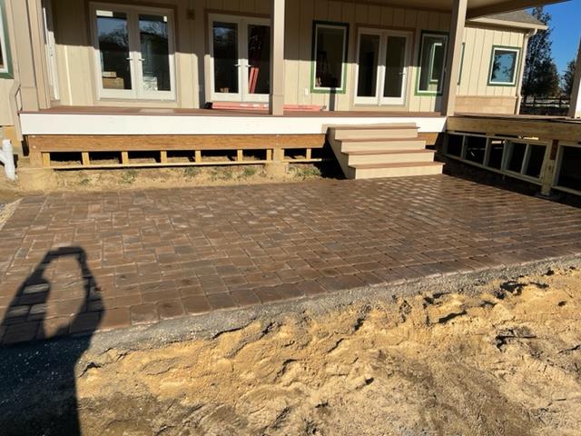 A house with a patio and stairs in front of it.