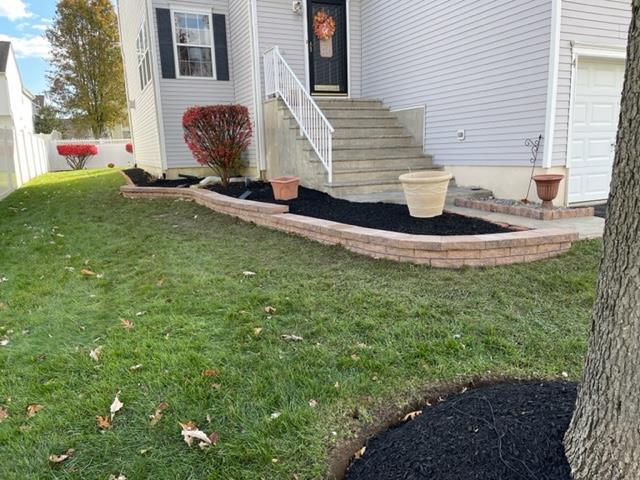A house with a lush green lawn and a tree in front of it.