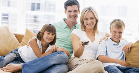 Family smiling sitting on couch