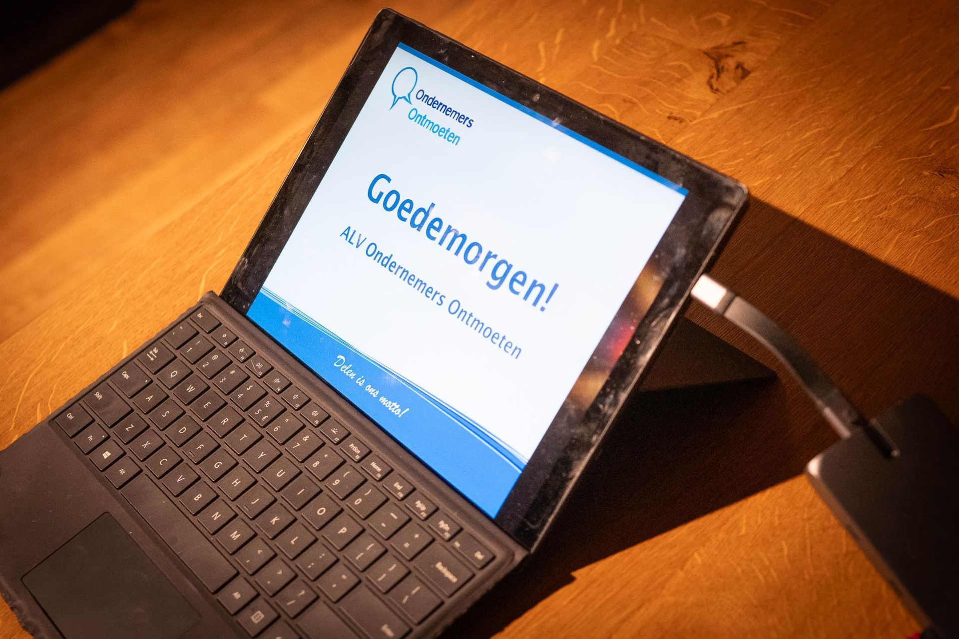 Op een laptop op een houten tafel staat de tekst