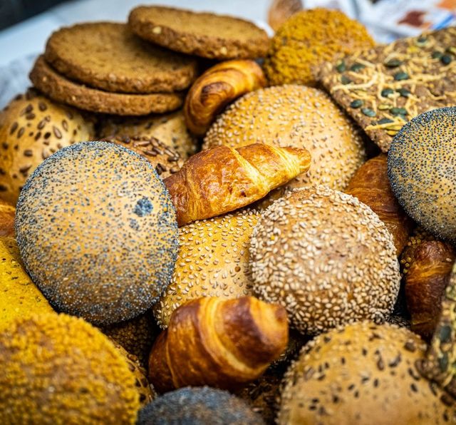Diverse soorten brood en gebak, waaronder broodjes, croissants en crackers.