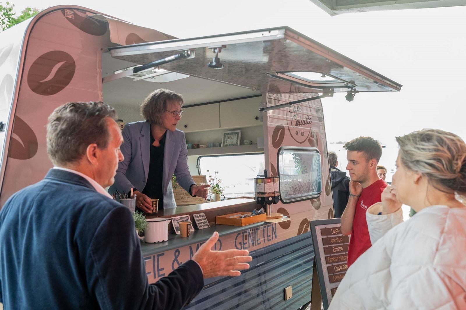 Een groep mensen staat rond een foodtruck.