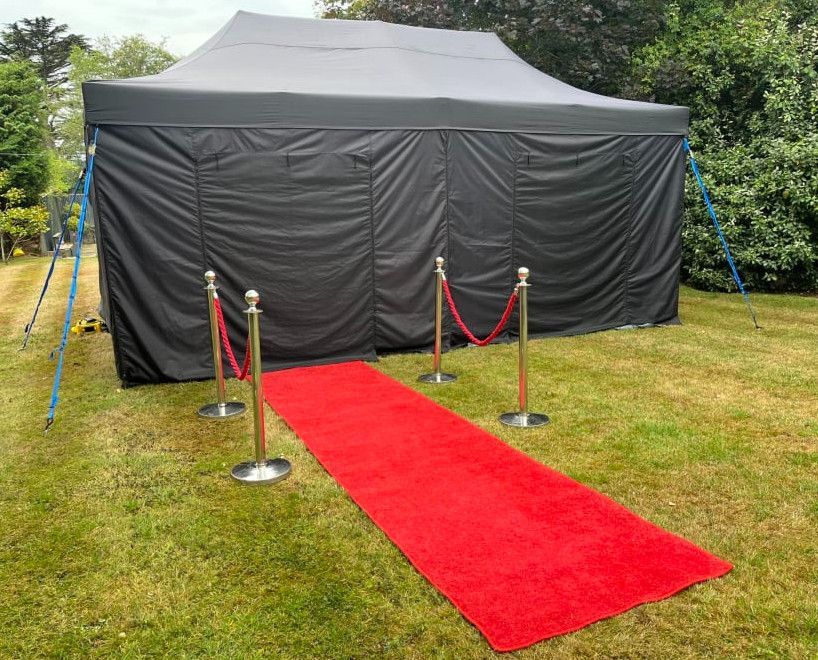 A red carpet is leading to a black tent