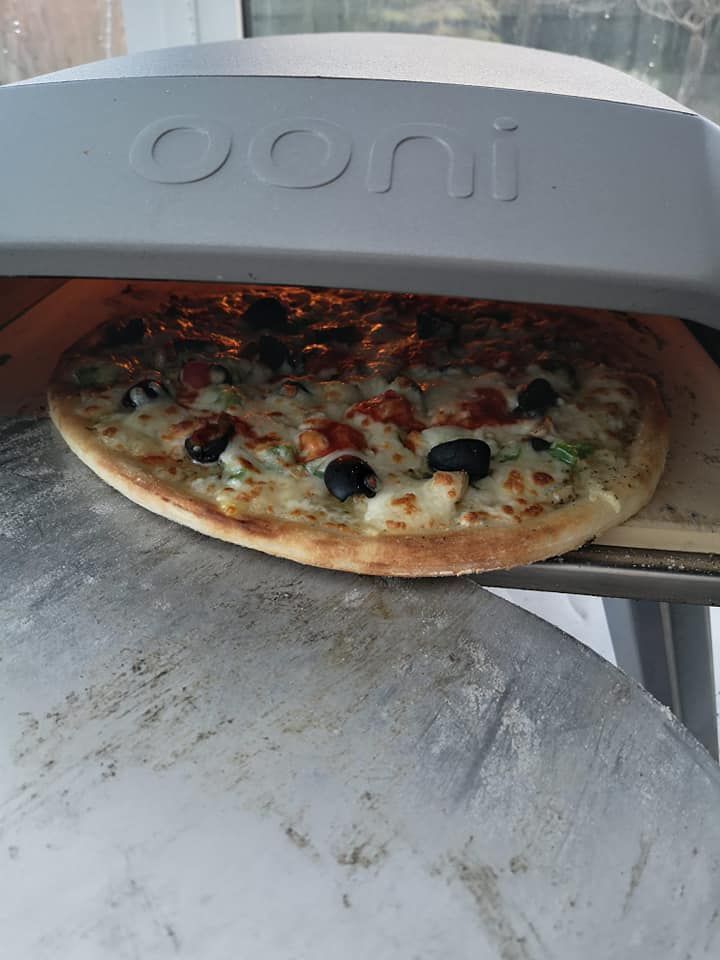 A pizza is being cooked in a pizza oven.