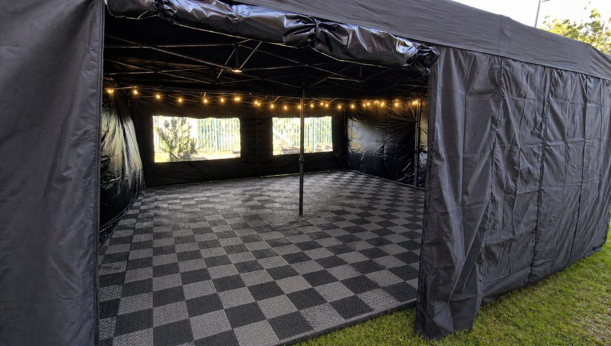 Black 6m x 3m pop-up canopy tent with side walls on grass outdoors