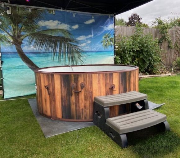 A wooden hot tub with steps in a backyard with a palm tree in the background.