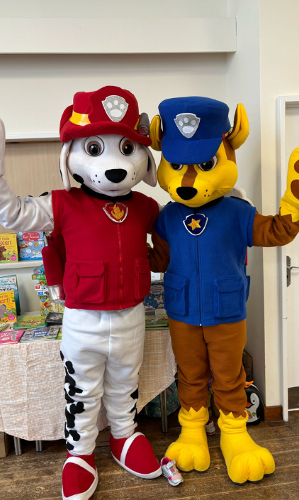 Two paw patrol mascots , marshall and chase , are standing next to each other.